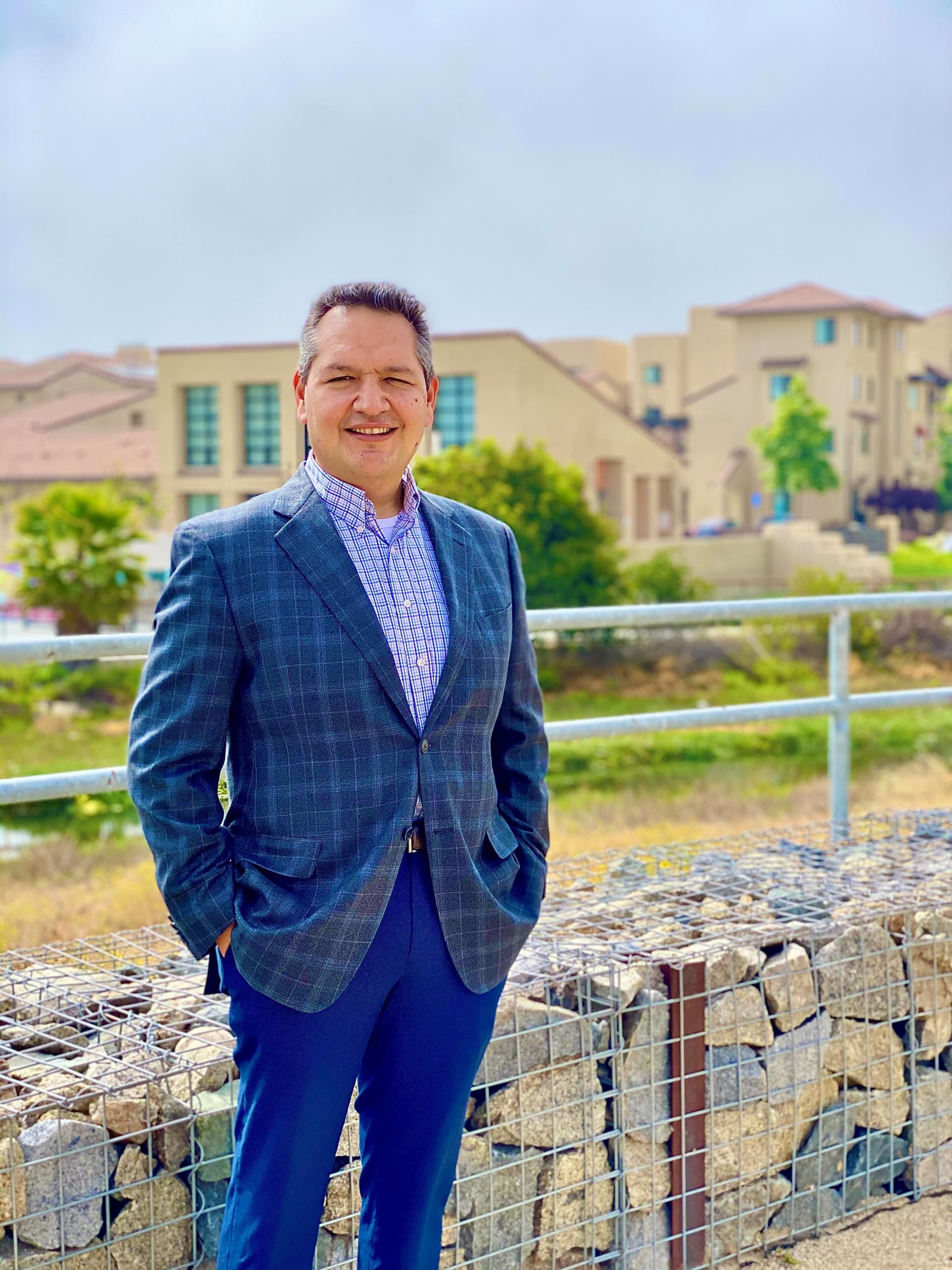 Picture of Carlos Aguirre, the Housing Authority Director, in front of Paradise Creek Apartments